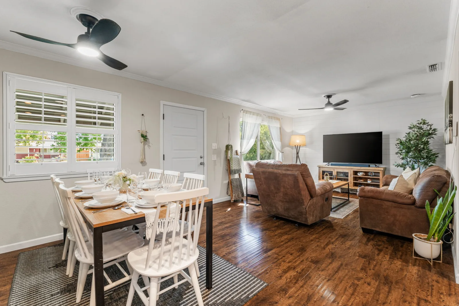 Dining table set for guests beside the open living room